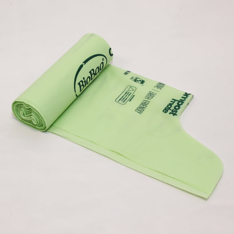 Close up of Compost Mate bio-plastic liner roll highlighting official AS5810 home compostable and AS4736 commercial compostable certifications showing wave top.