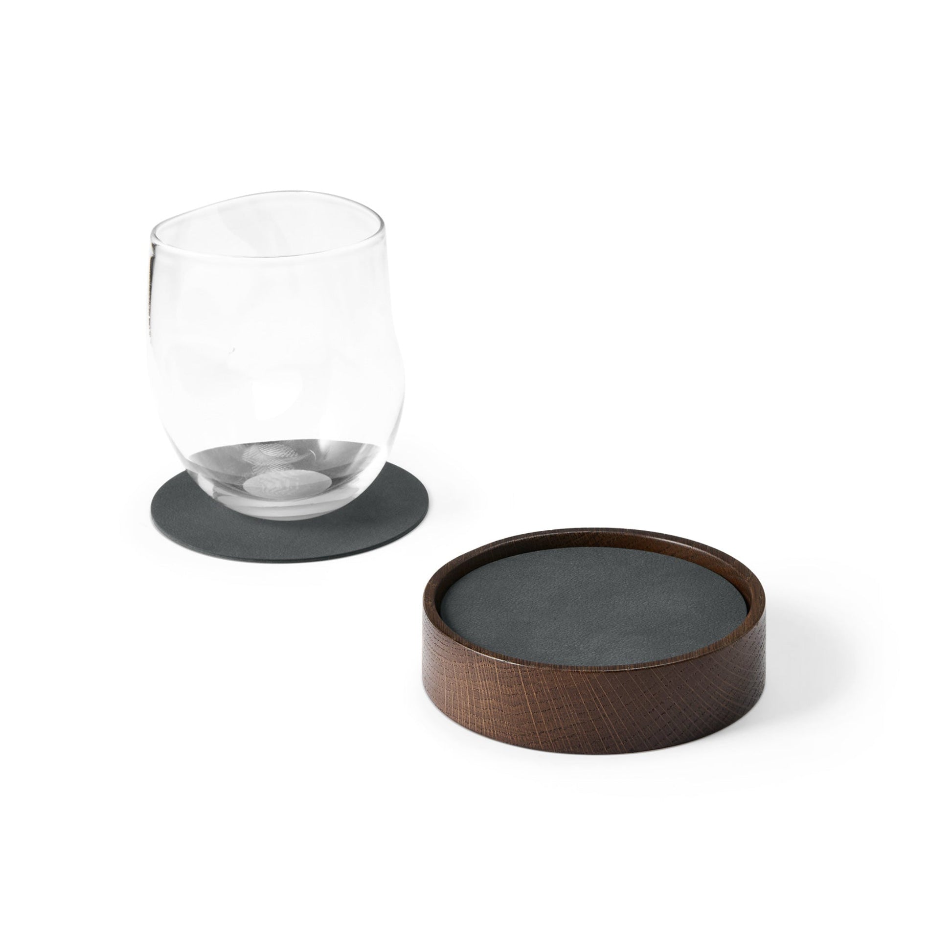 Circle recycled leather coaster box with coasters with a single coaster and glass showing LIND DNA texture.