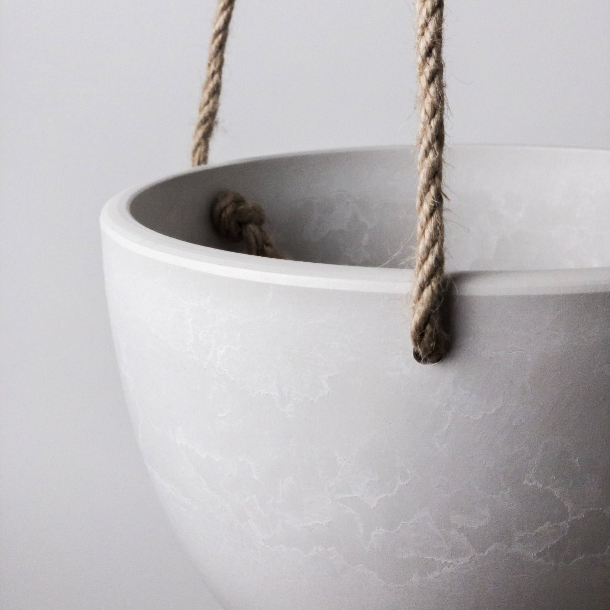 Single Columbia recycled plastic hanging planter bowl in white showing a close up of the hemp rope and stone like texture.