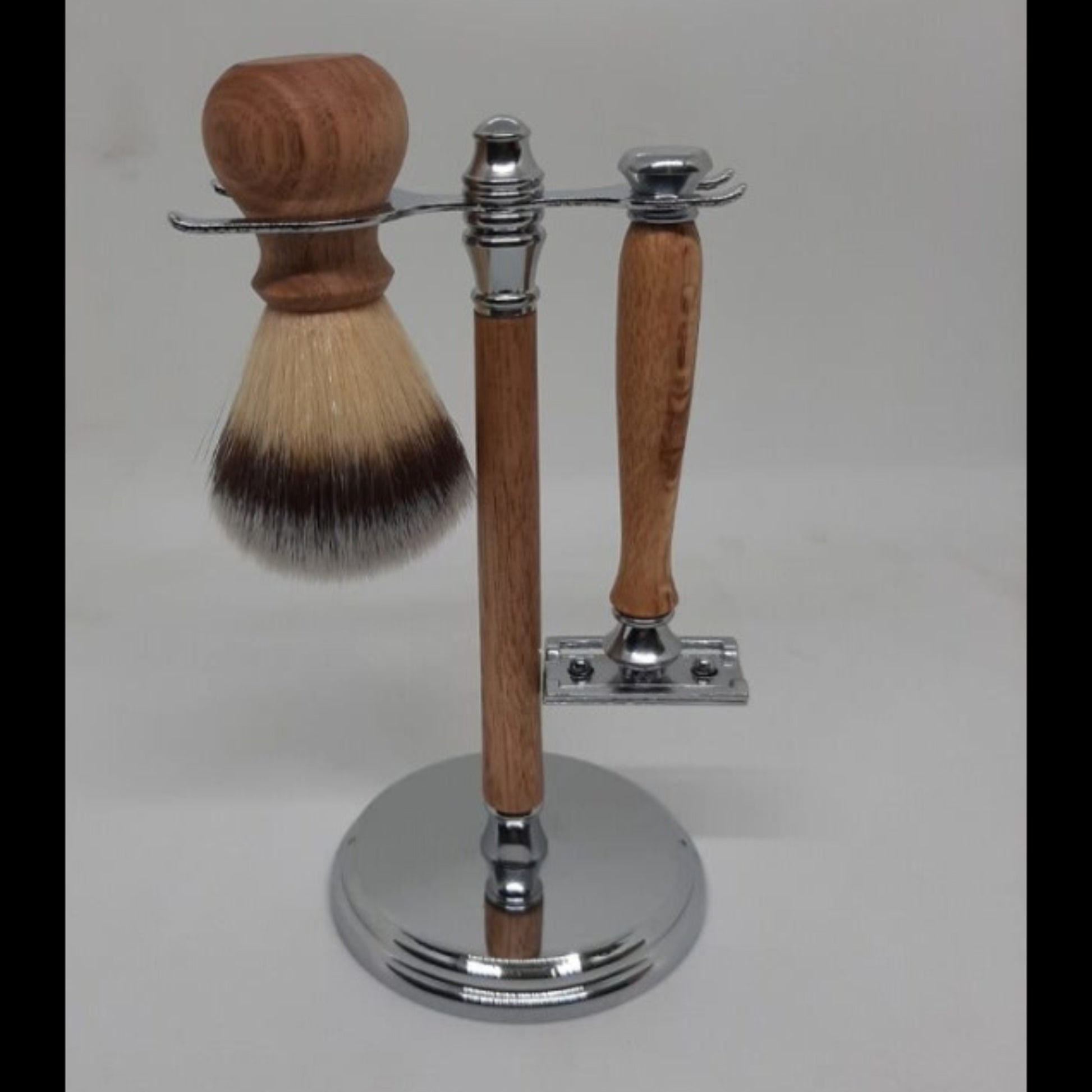 A premium 3-piece traditional men's grooming kit showing  a hand-turned recycled timber double-edge safety razor and matching shave brush on an organized wooden display stand, handcrafted in Australia in chrome.