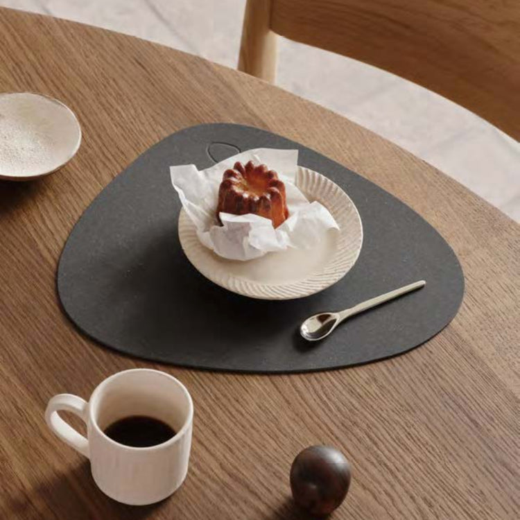 Curve recycled leather placemat featuring the signature LIND DNA Core texture on a table set with plate, saucer, spoon and cup.