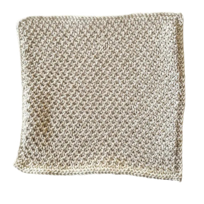Cream handmade knitted dishcloth made from absorbent recycled cotton for kitchen and bathroom use on a white background.