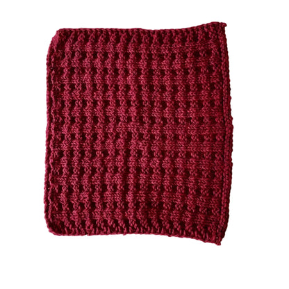 Dark red handmade knitted dishcloth made from absorbent recycled cotton for kitchen and bathroom use.