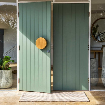 Premium natural stripe durable front door mat placed outside a modern green double-door entryway.