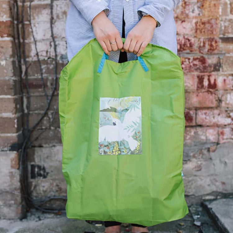 Shopper using a durable and spacious Onya reusable bag to pack fresh market groceries during a zero waste shopping trip in Melbourne.