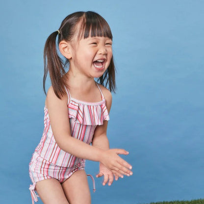 Young girl modeling the Tyoub gelato pink striped off-the-shoulder ruffle swimsuit for sun smart safety in Australia.