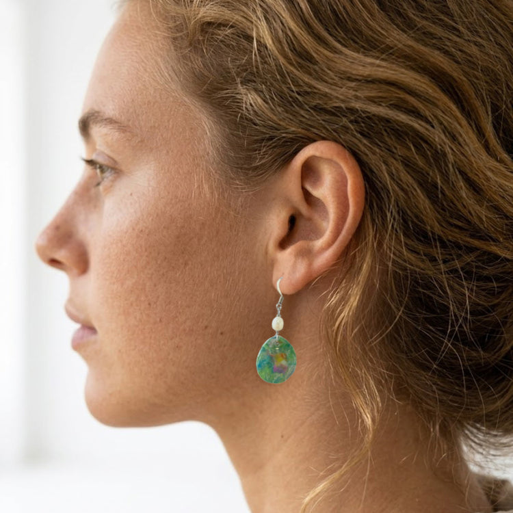 On-model shot showcasing the fit and length of the upcycled green nebula statement dangle earrings with white pearls, styled in Australia.