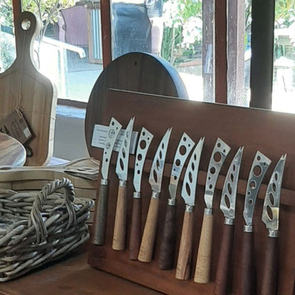 Row of  high-quality stainless steel cheese knives with a hand-turned recycled timber handle on a magnetic board, made by Lyons Woodturning in Jindera, New South Wales.