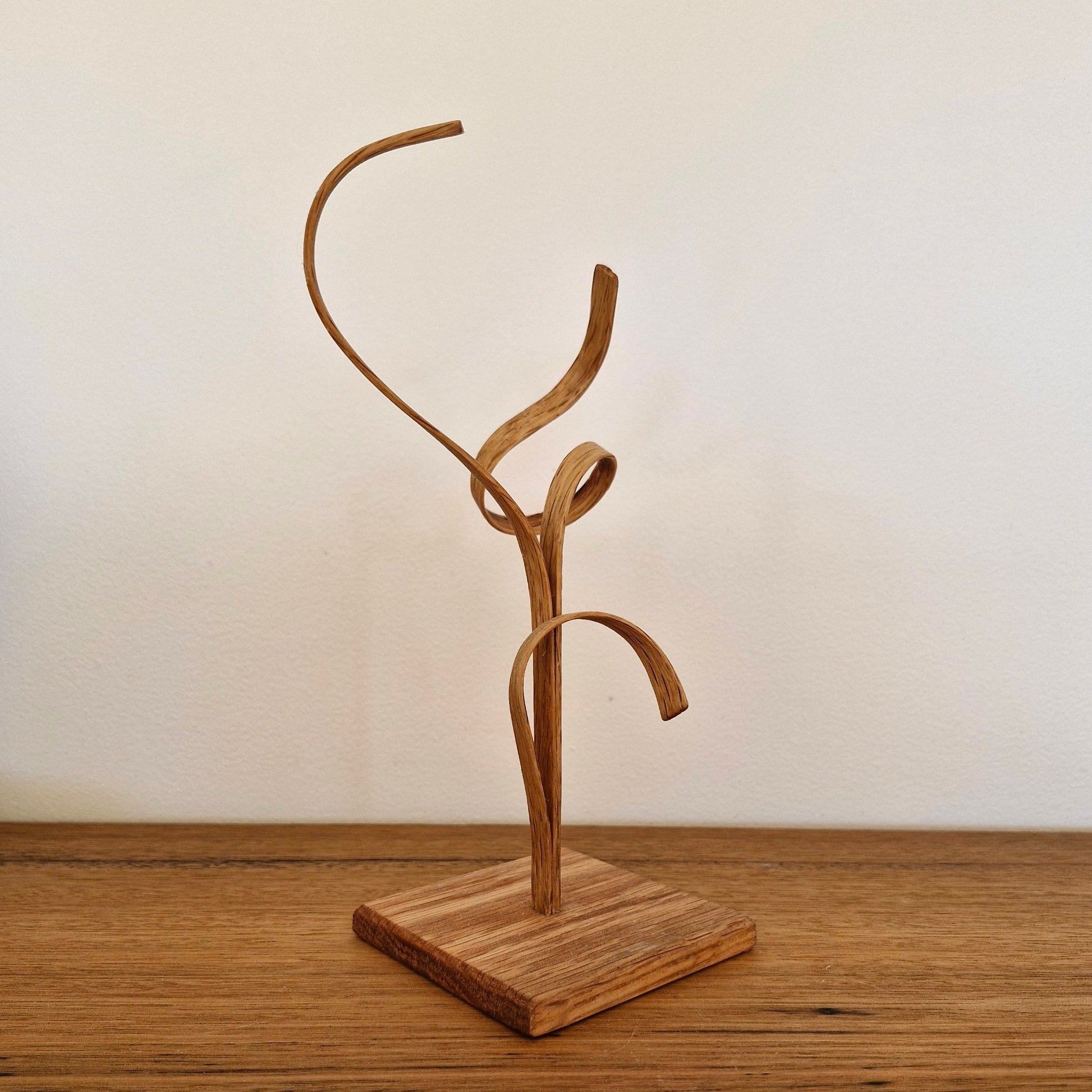 Back view of handcrafted American Oak sculpture showing organic steam-bent curves and natural wood grain.