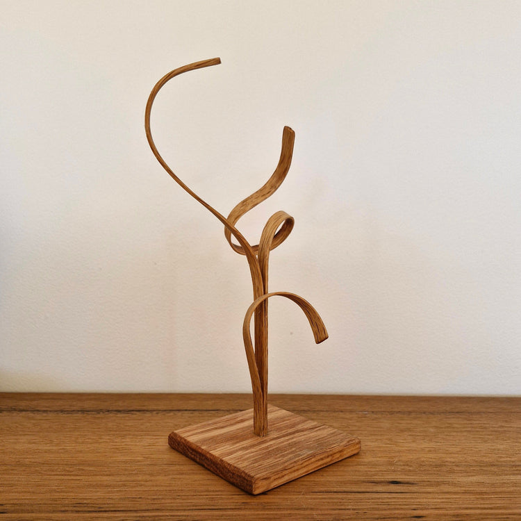 Back view of handcrafted American Oak sculpture showing organic steam-bent curves and natural wood grain.