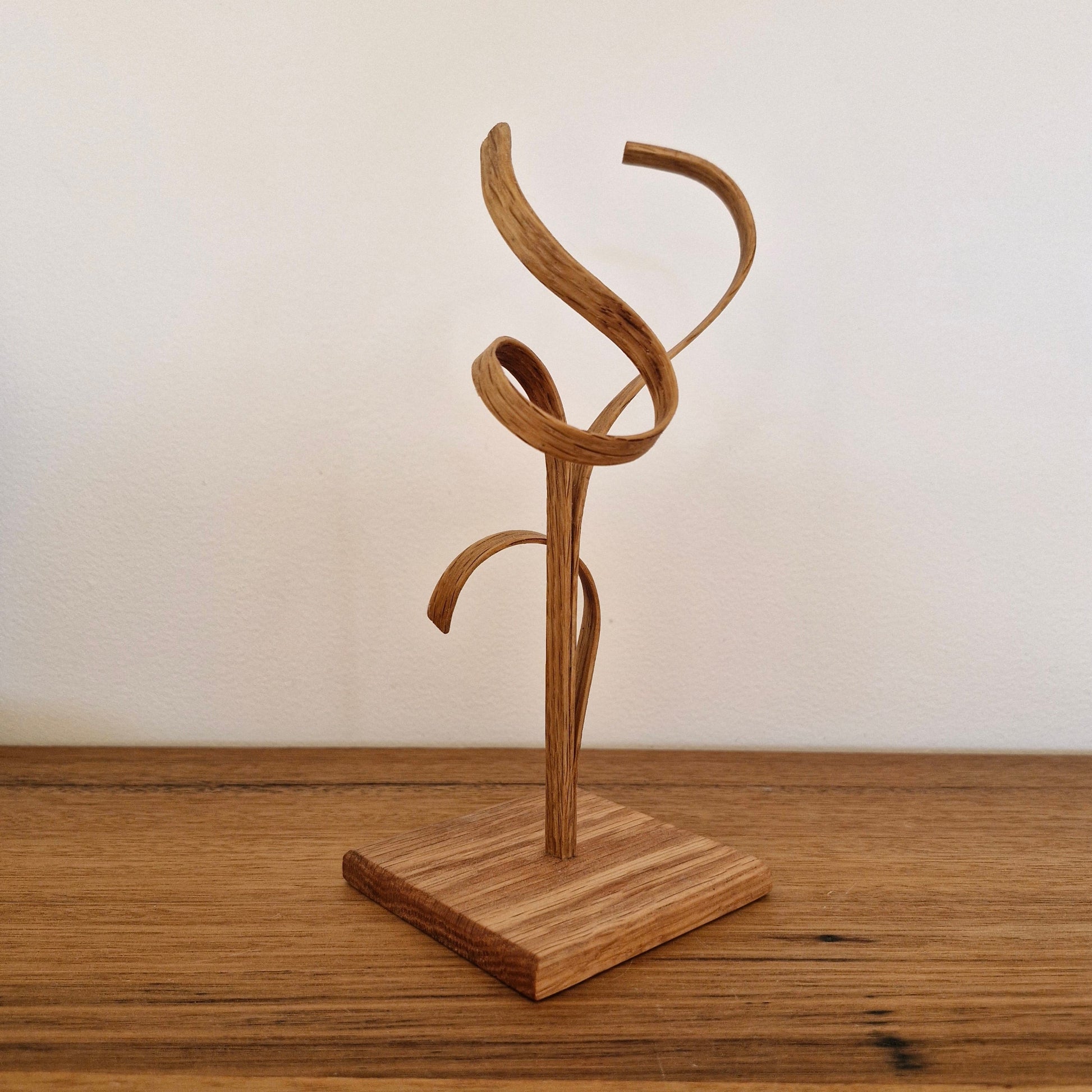Side view of Upcycled Wood Design timber sculpture showing organic steam-bent curves and natural wood grain.