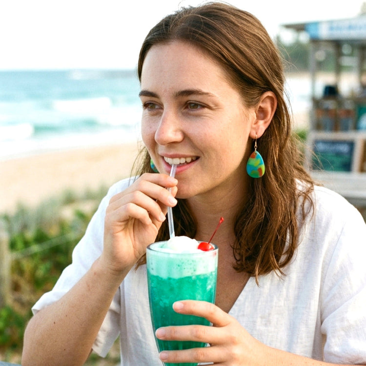 On-model shot of a person wearing the clear blue drop dangle statement earrings, showcasing their length and how they sit.