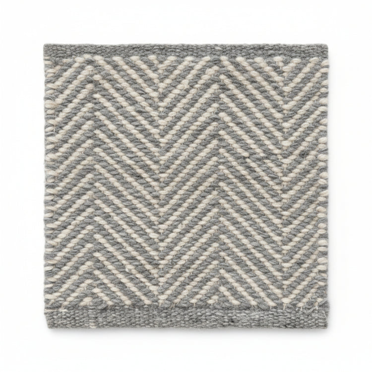 Close-up texture detail of the sustainable herringbone weave pattern on a Henshall grey recycled plastic floor mat.