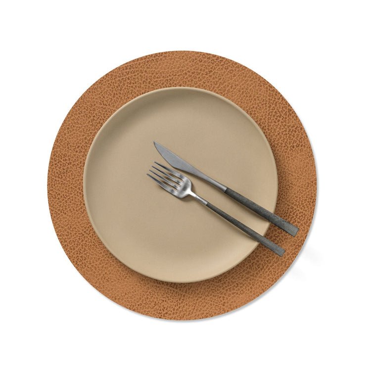 Circle recycled leather placemat featuring the signature LIND DNA Hippo texture wiht plate setting in nature.