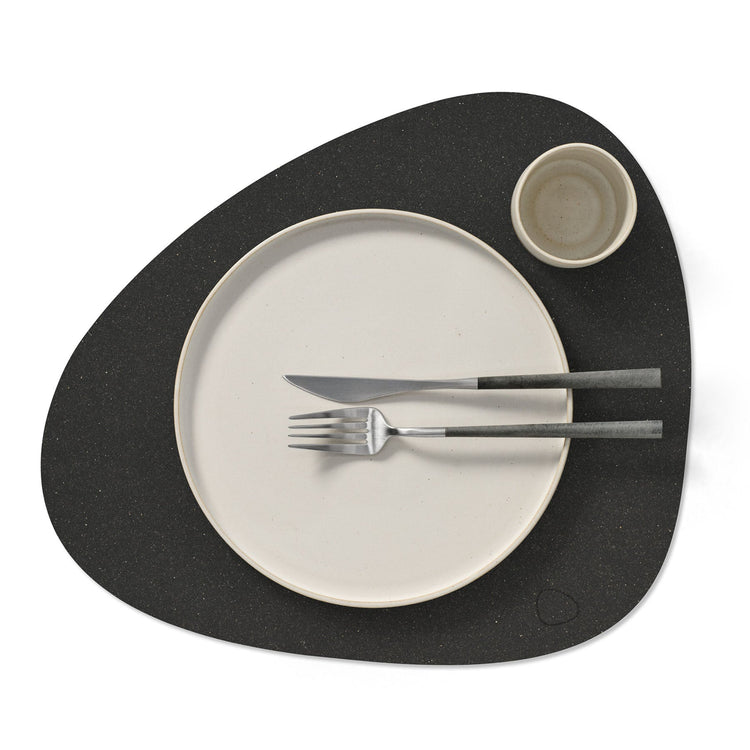 Curve recycled leather placemat featuring the signature LIND DNA Hippo texture in black anthracite with plate, fork, knife and cup.