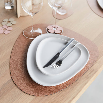 LIND DNA Curve Table Mat in Hippo finish on a wooden table set with white plates, glasses and cutery