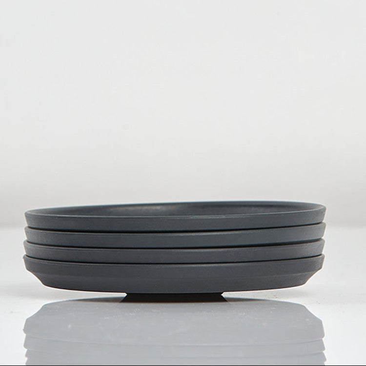 Pack of 4 Huskee small 3oz espresso saucers featuring the signature vertical ribbed design made from sustainable coffee husk waste side view In charcoal.