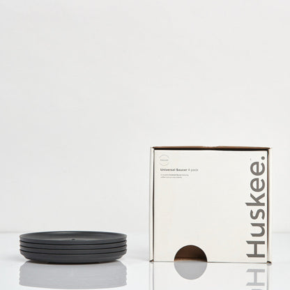 Pack of 4 universal Huskee Classic coffee saucers made from sustainable coffee husk waste with its box in charcoal.