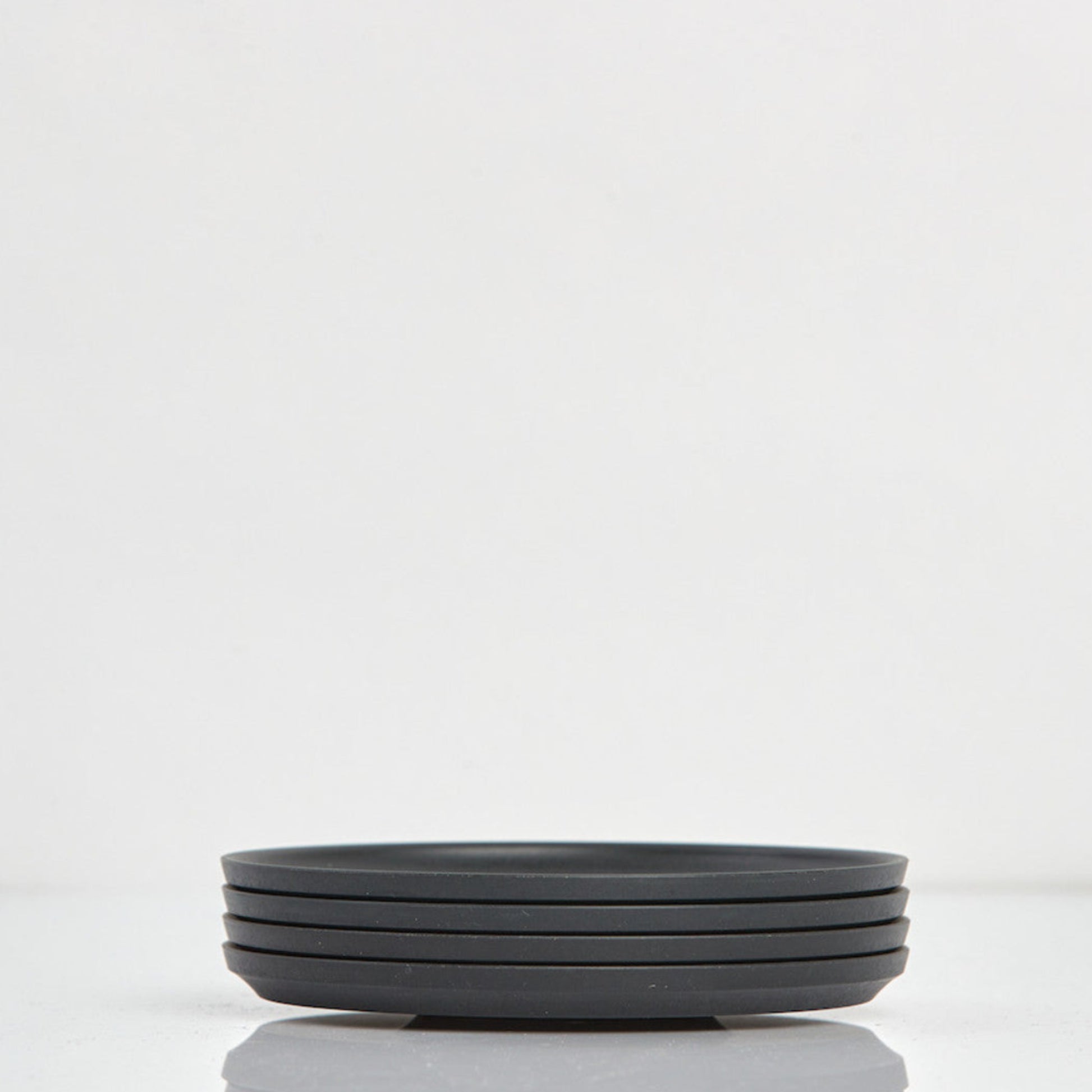 Pack of 4 universal Huskee Classic coffee saucers made from sustainable coffee husk waste in charcoal.