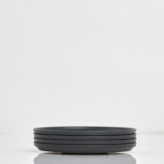 Pack of 4 universal Huskee Classic coffee saucers with signature ribbed design made from sustainable coffee husk waste in charcoal.