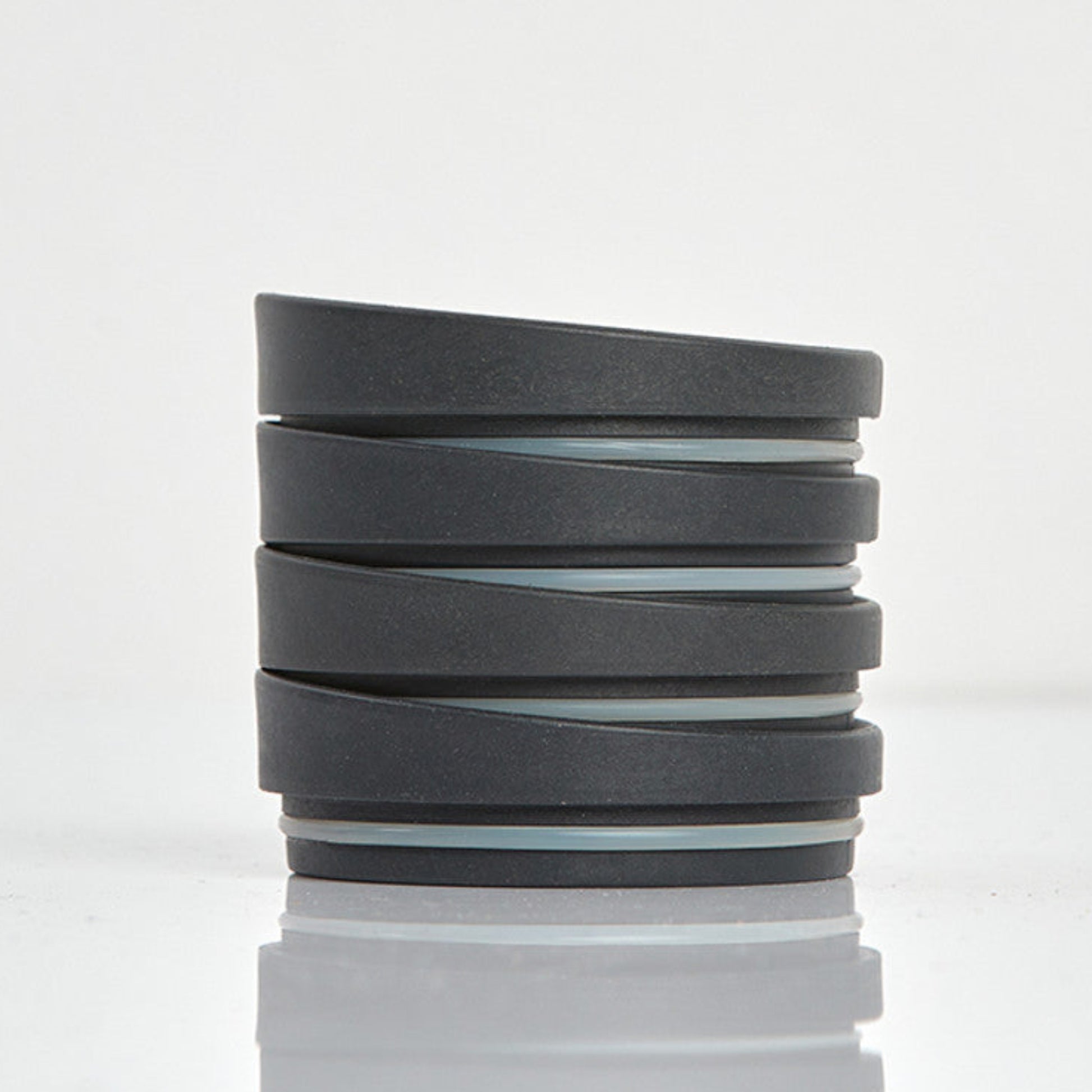 Pack of 4 universal Huskee reusable coffee cup lids made from sustainable organic coffee husk waste in charcoal.