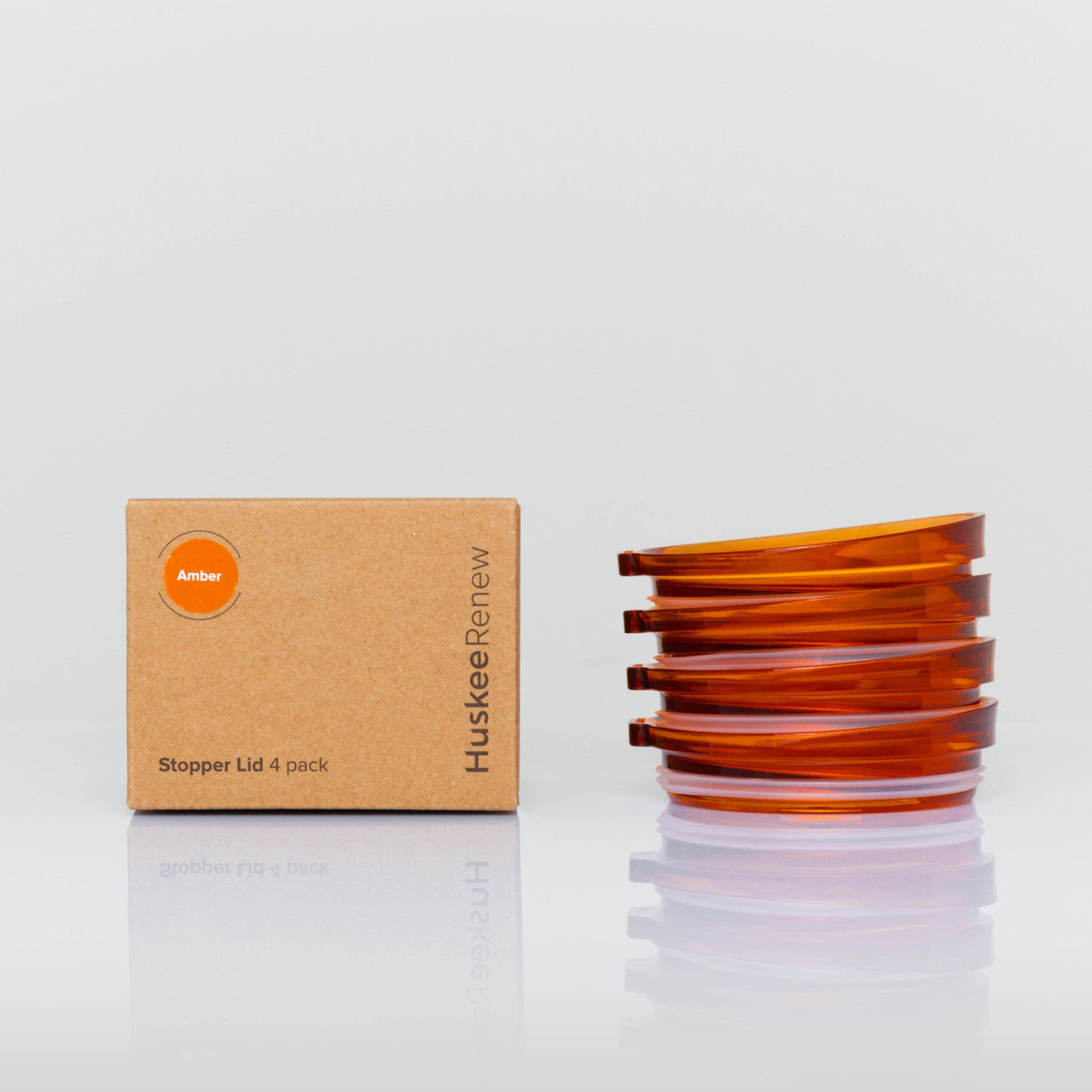 4 pack universal Huskee stopper lid featuring a spill-proof reusable design with integrated silicone seal in amber with box.