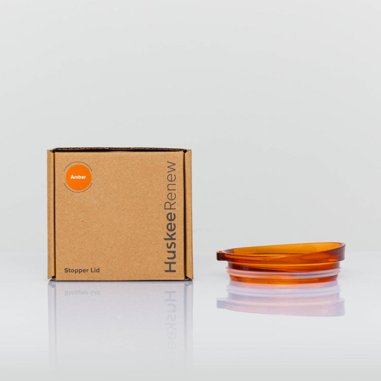 A single individual universal Huskee stopper lid featuring a spill-proof reusable design with integrated silicone seal in amber with box.