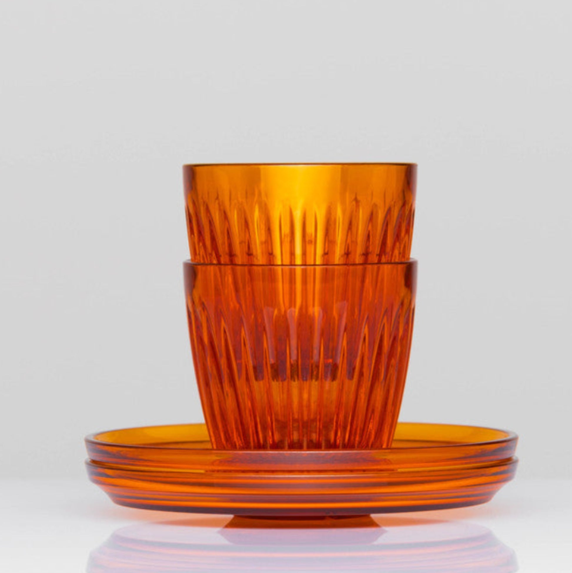 Complete HuskeeRenew 3oz espresso set of two cups and two matching saucers crafted from premium translucent recycled polymer in amber.