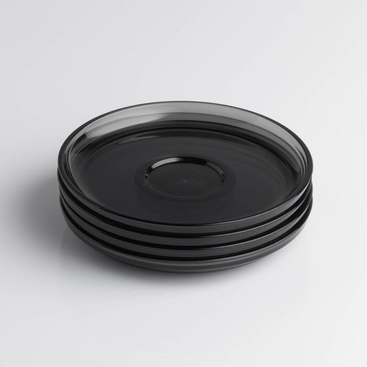Pack of 4 HuskeeRenew translucent reusable small 3oz espresso saucers featuring the signature vertical ribbed design made from high-performance recycled polymer top view in smoke.