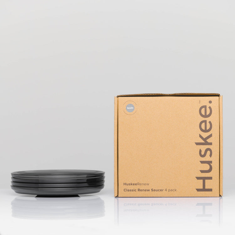 Pack of 4 translucent HuskeeRenew classic coffee saucers made from high-quality recycled polymers in smoke with box.