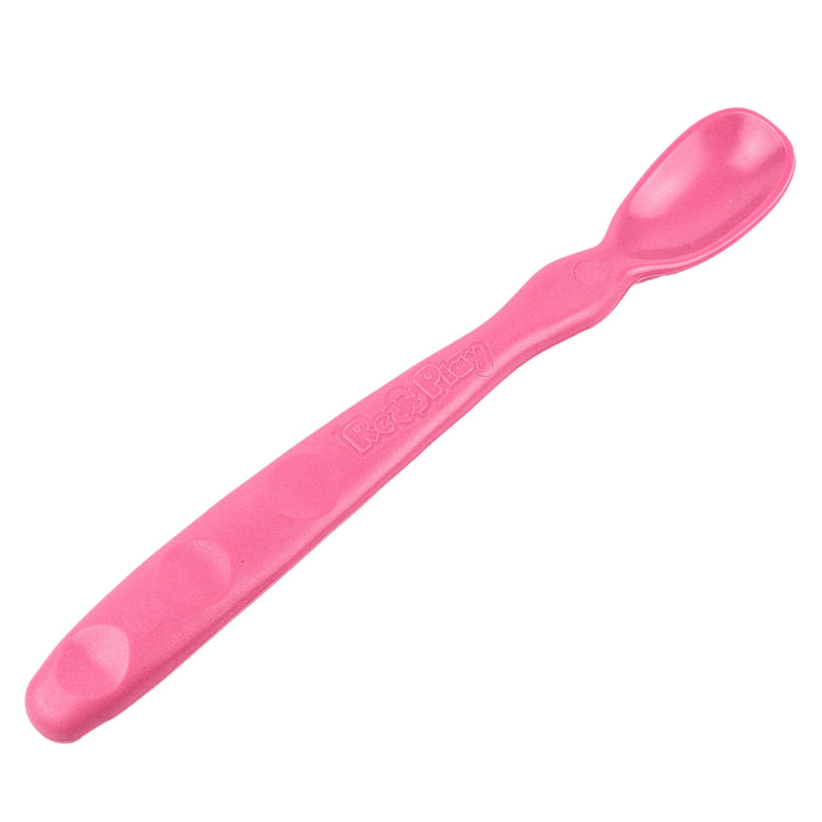 Close up view of the smooth rounded contour edges and gentle deep scoop depth on a non toxic infant weaning spoon in bright pink.