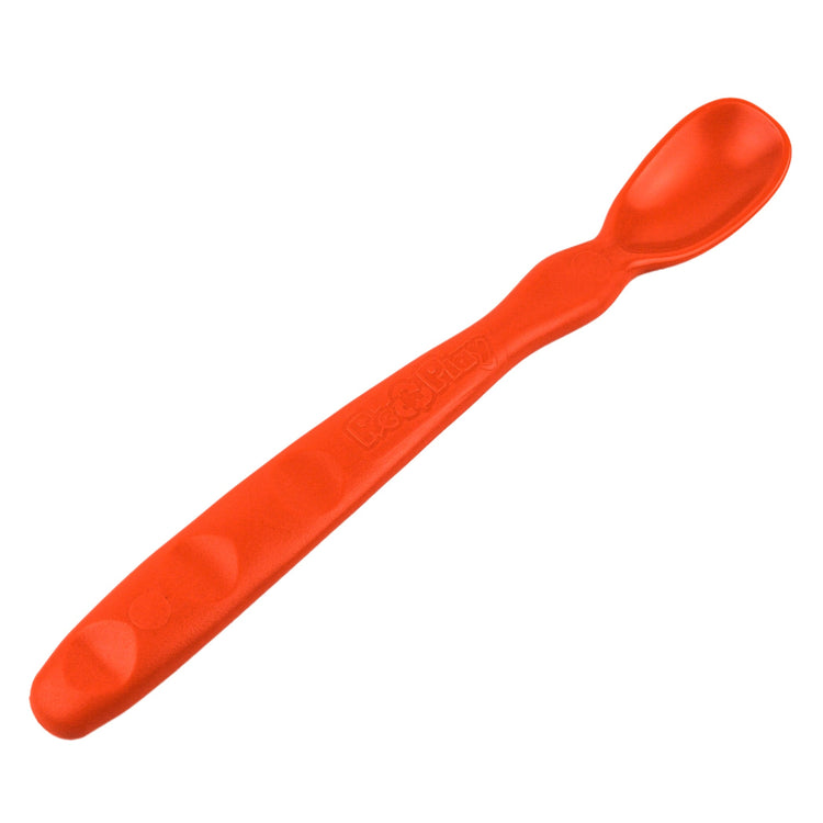 Close up view of the smooth rounded contour edges and gentle deep scoop depth on a non toxic infant weaning spoon in red.