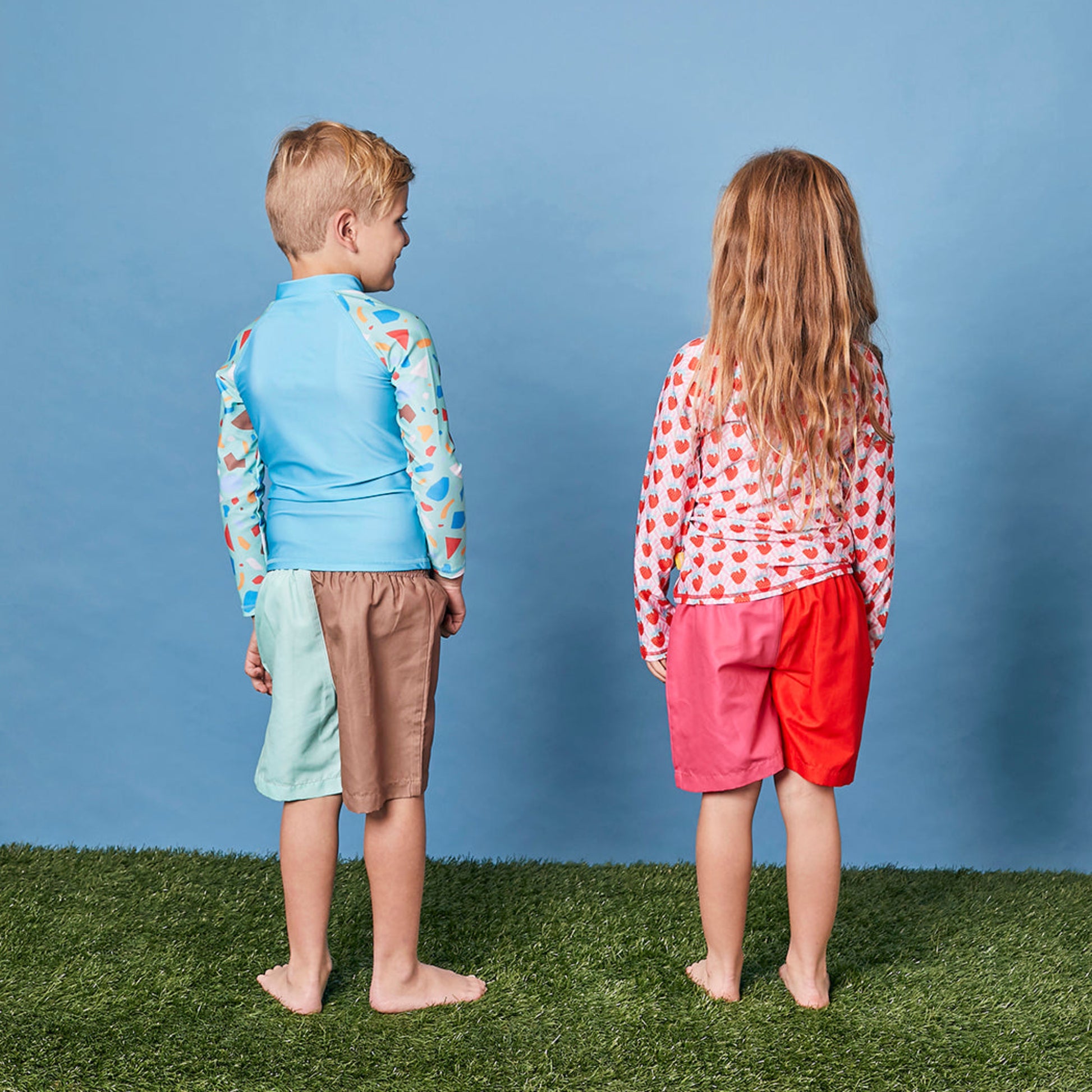 Rear profile of a child wearing the long sleeve strawberry swim shirt for sun smart UV protection in Australia.