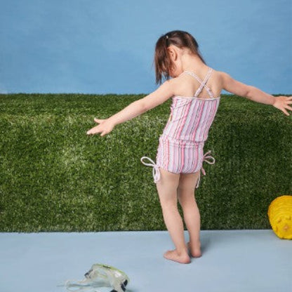Rear view of a child wearing the striped ruffle bather set, showcasing the asymmetrical strap and back coverage.