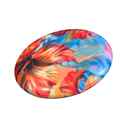 Standalone 230mm flying disc made from recycled Fijian beach waste showing vibrant, one-of-a-kind upcycled colour patterns in floral 1.