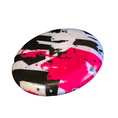Standalone 230mm flying disc made from recycled Fijian beach waste showing vibrant, one-of-a-kind upcycled colour patterns in graffiti.