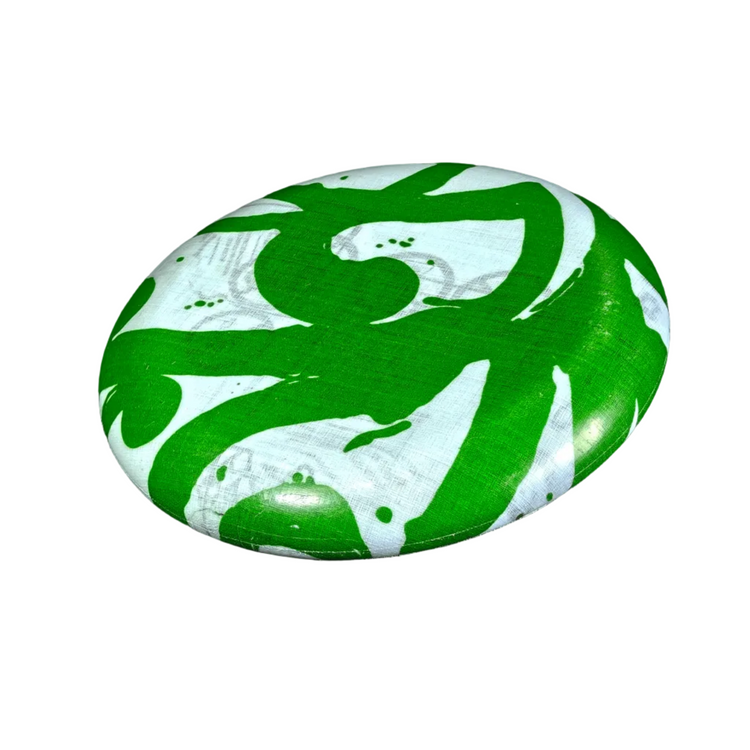 Standalone 230mm flying disc made from recycled Fijian beach waste showing vibrant, one-of-a-kind upcycled colour patterns in green spiral.