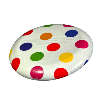 Standalone 230mm flying disc made from recycled Fijian beach waste showing vibrant, one-of-a-kind upcycled colour patterns in polka dot.