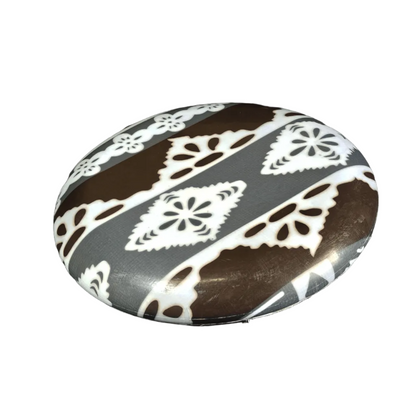 Standalone 230mm flying disc made from recycled Fijian beach waste showing vibrant, one-of-a-kind upcycled colour patterns in print black.