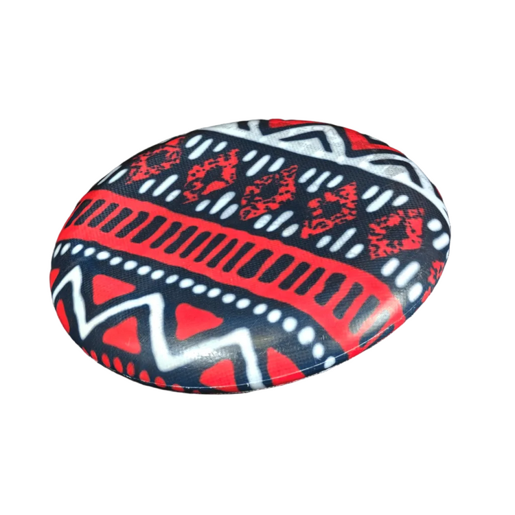 Standalone 230mm flying disc made from recycled Fijian beach waste showing vibrant, one-of-a-kind upcycled colour patterns in print red.