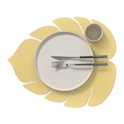 Monstera leaf recycled leather placemat sstyled with a plate, cup, knife and ork in gold