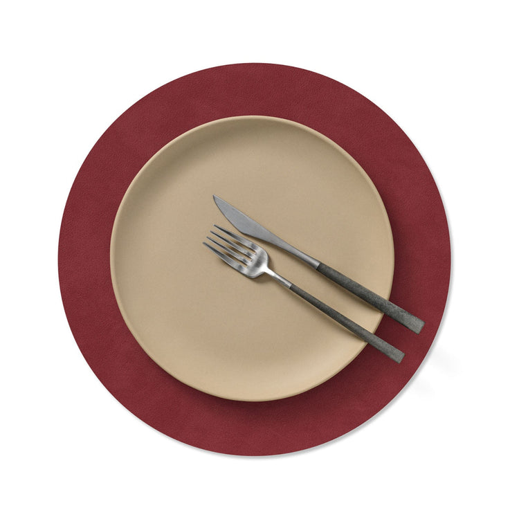 Circle recycled leather placemat featuring the signature LIND DNA Nupo texture with plate setting in red.
