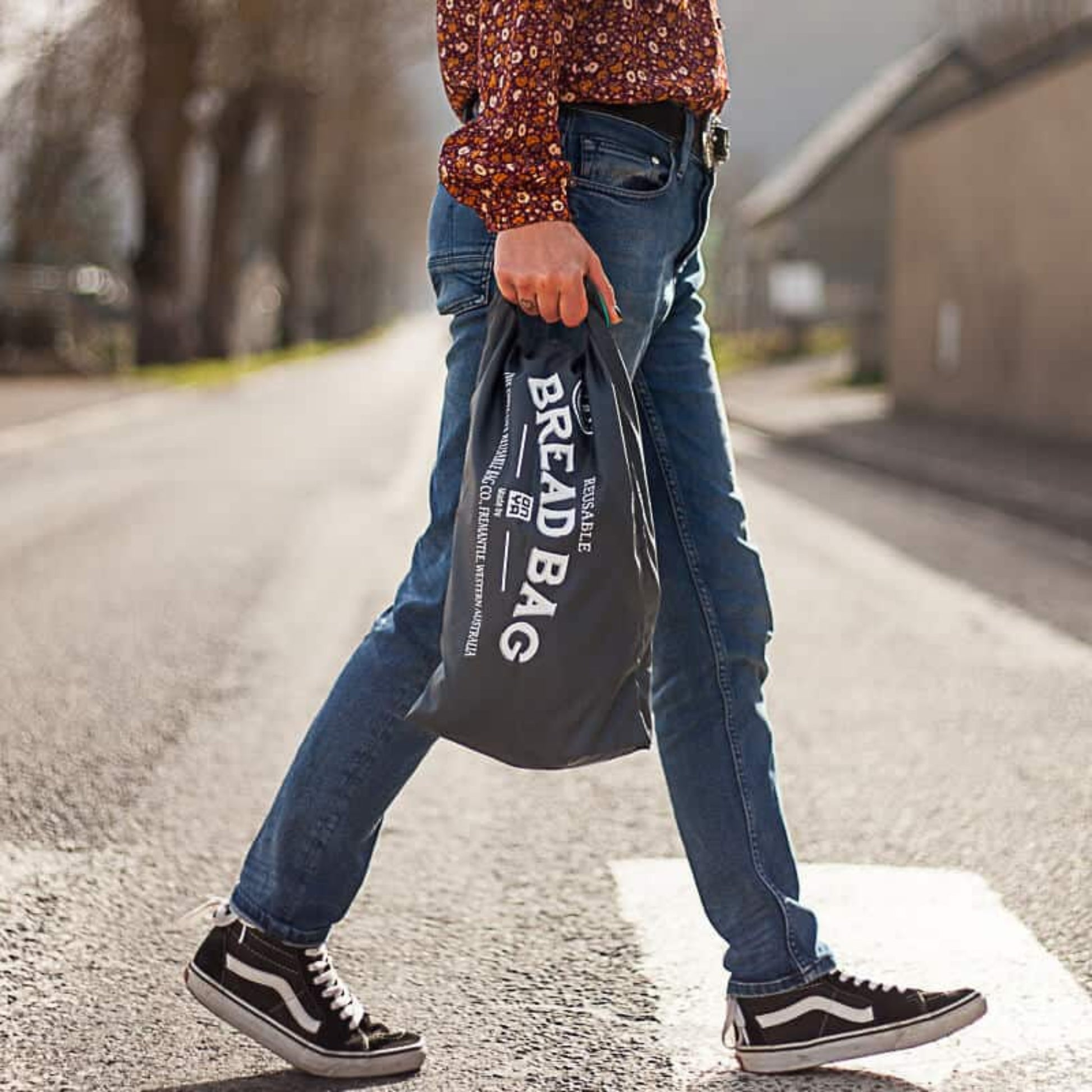 Man crossing a road carrying an ONYA 100% rPET bread bag, Double lined for freshness and freezer protecion, roll and clip closure, BPA free.