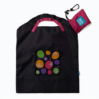 Onya reusable shopping bag with built in shoulder strap and checkout caddy loops next to its attached compact pouch on a clean white background, available in Australia in black retro small variant.