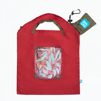 Onya reusable shopping bag with built in shoulder strap and checkout caddy loops next to its attached compact pouch on a clean white background, available in Australia in red dark leaves small variant.
