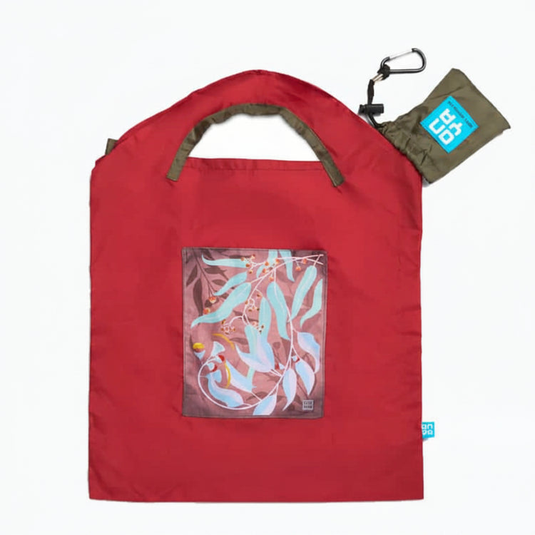 Onya reusable shopping bag with built in shoulder strap and checkout caddy loops next to its attached compact pouch on a clean white background, available in Australia in red dark leaves small variant.