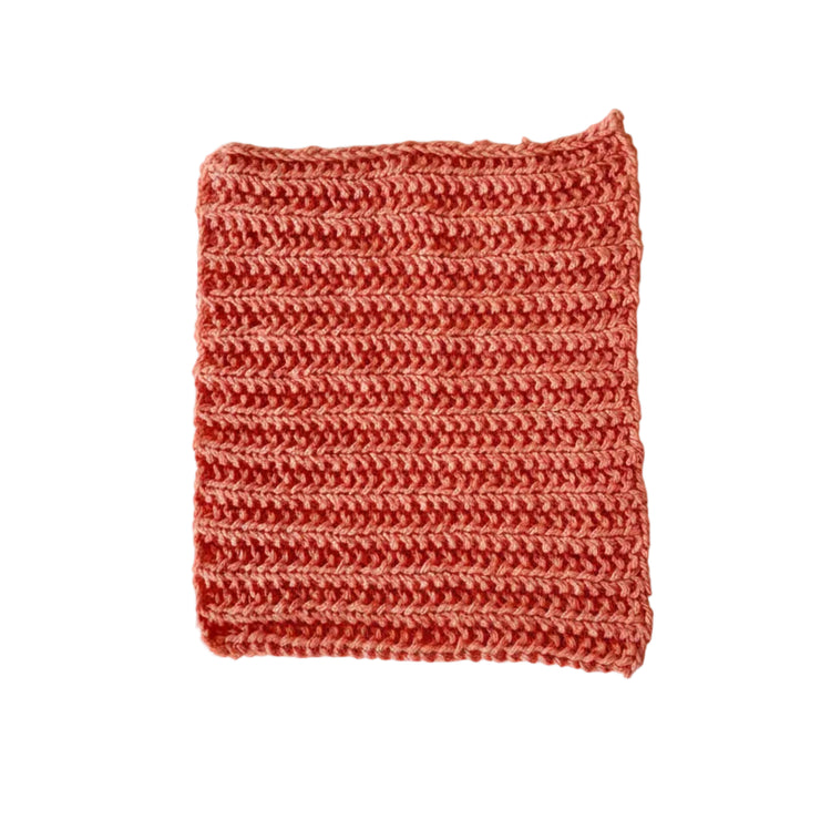 Orange handmade knitted dishcloth made from absorbent recycled cotton for kitchen and bathroom use.
