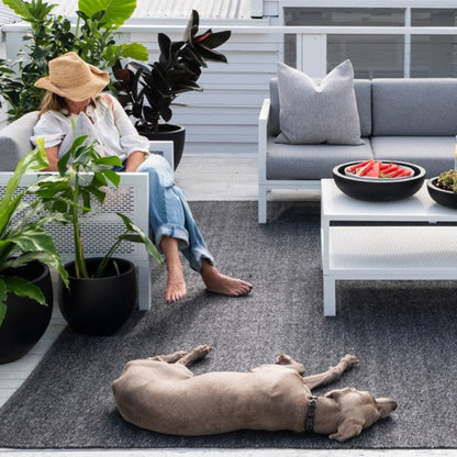 Zebra Home Clements stain-resistant and pet-friendly recycled plastic outdoor rug styled in a backyard entertainment area.