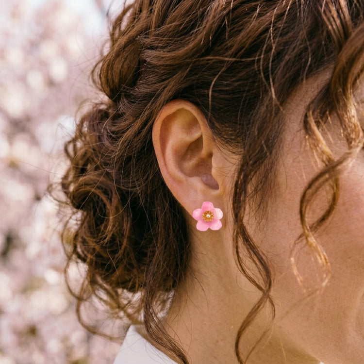 On-model style photo showcasing the fit, size, and 3D floral form of the pink Sakura cherry blossom recycled stud earrings.
