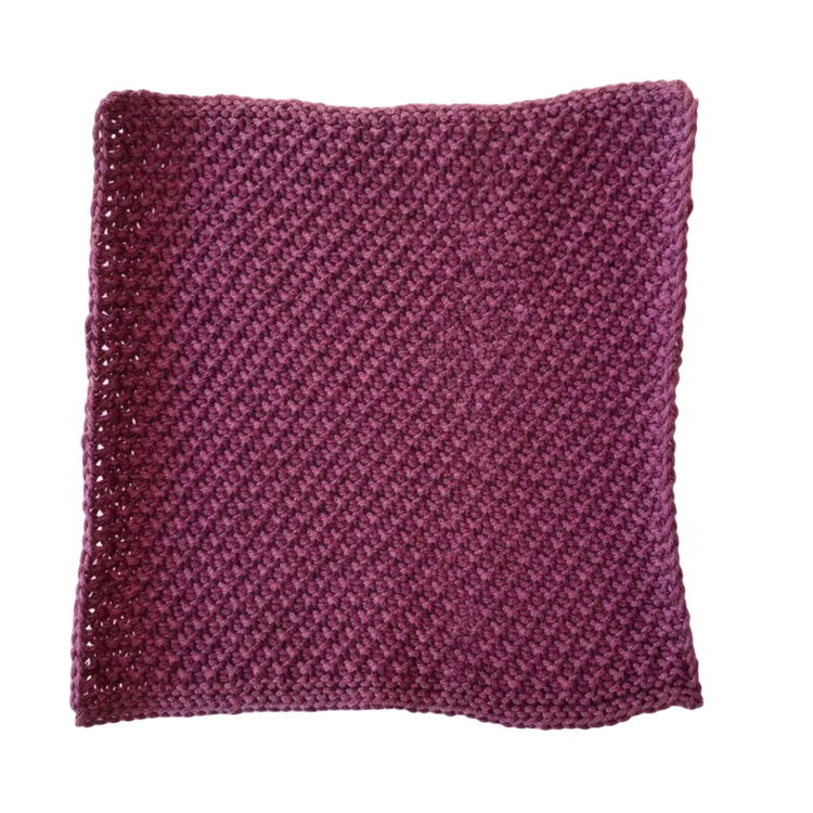 Plum handmade knitted dishcloth made from absorbent recycled cotton for kitchen and bathroom use on a white background.